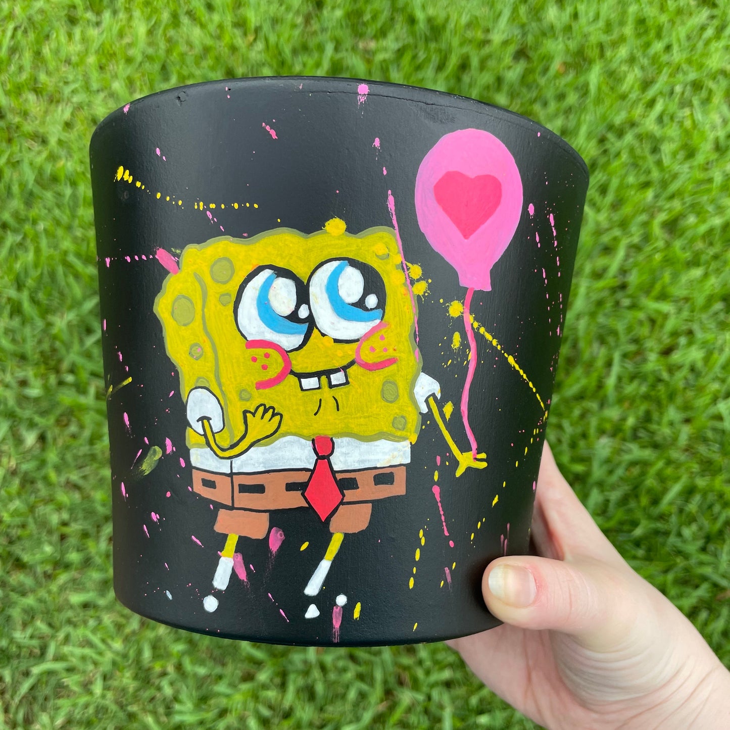 6.5-inch matte black terracotta pot depicting a hand-painted SpongeBob in love design.