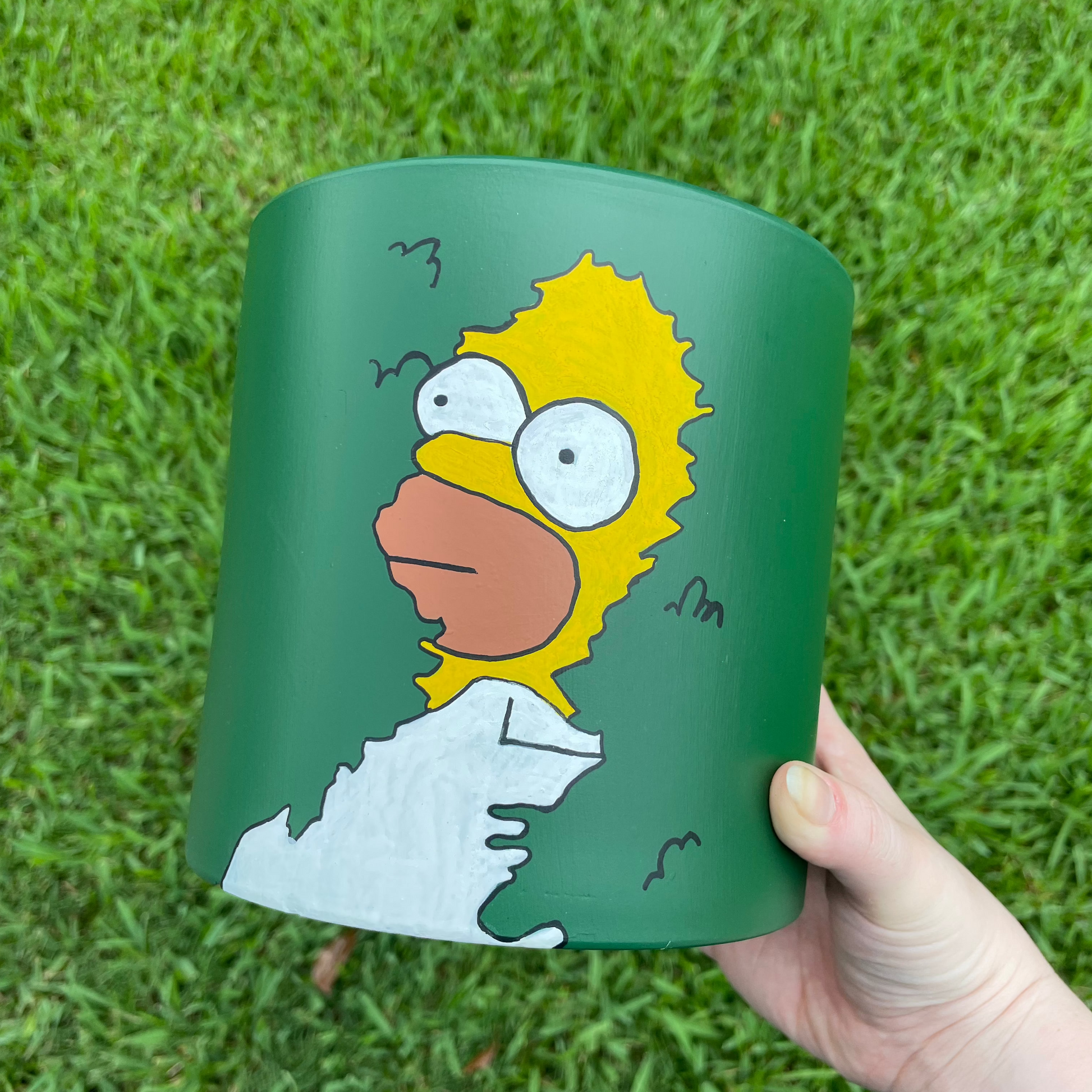 Terracotta pot depicting the iconic Homer Simpson bush meme in a 180-degree hand-painted design.