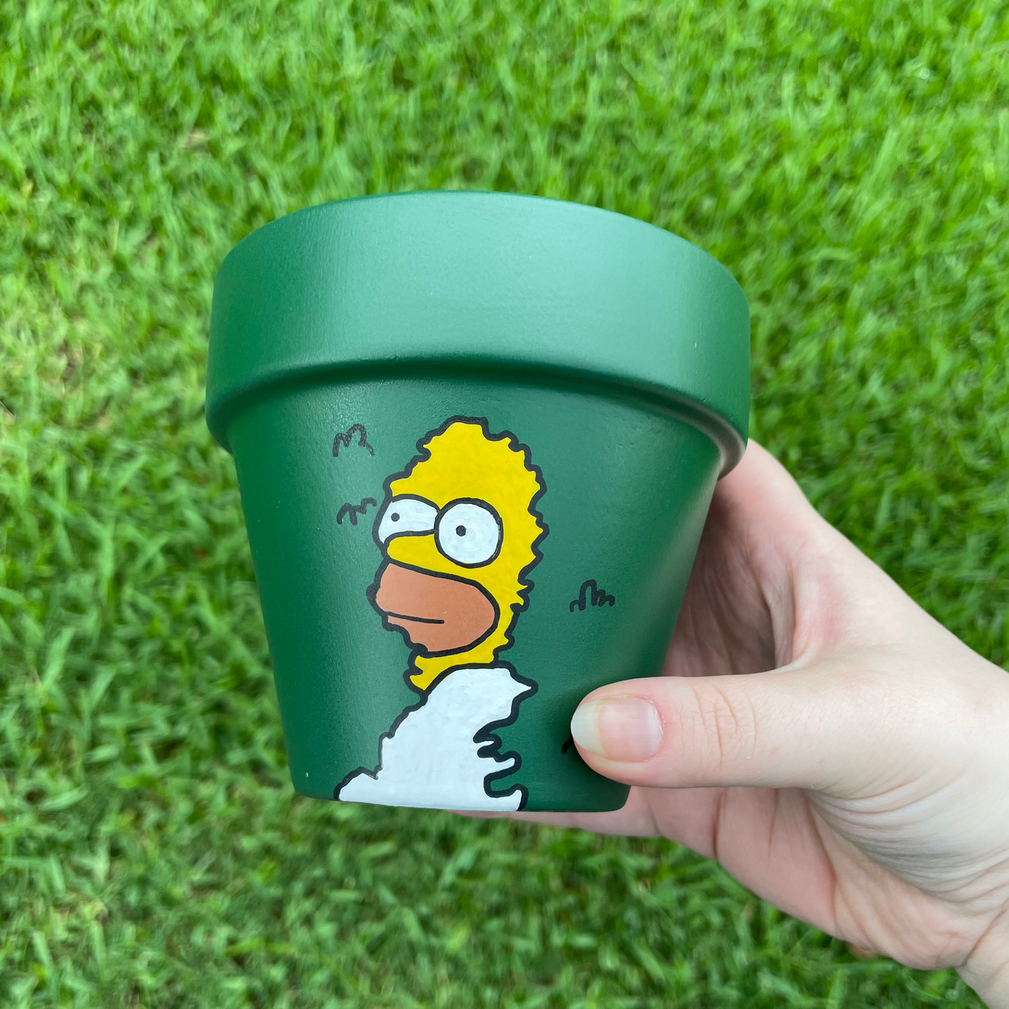 Terracotta pot depicting the iconic Homer Simpson bush meme in a 180-degree hand-painted design.
