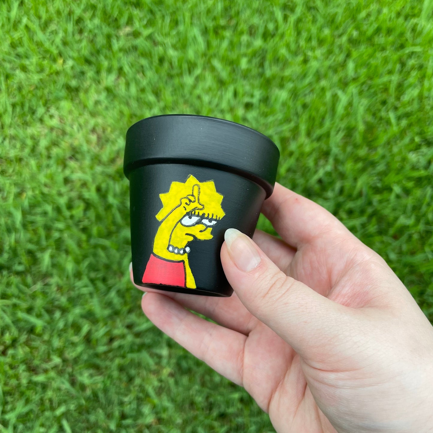 2-inch matte black terracotta pot featuring a hand-painted image of Lisa Simpson with 'Loser' text.